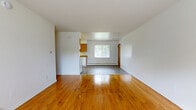 Located at 218 Surrey Dr in Bristol, CT, this one-bedroom, one-bathroom unit offers a practical and well-organized single-floor layout. The open-concept living area is a standout feature, showcasing gleaming, warm-toned hardwood floors that extend throughout the main living space and bedroom. Large windows allow natural light to fill the rooms, offering views of the surrounding greenery and creating a bright, welcoming atmosphere. Baseboard heating runs along the walls, ensuring comfortable warmth throughout the colder New England seasons.

The galley-style kitchen is efficiently designed with warm wood cabinetry lining both walls, granite-toned countertops, white appliances including a range, dishwasher, and refrigerator, and durable vinyl plank flooring. A ceiling light fixture provides focused illumination for the workspace.

The bedroom is a comfortable size, featuring the same polished hardwood floors, a large window with exterior views, and a full-width closet with bifold doors for generous storage. Additional closets are located throughout the unit, providing exceptional organizational capacity. The bathroom includes a full tub and shower combination with clean white tile surround. A connecting hallway links all areas of the unit cohesively.