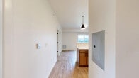 This single-floor, 3-bedroom, 1-bathroom unit in Wausau, Wisconsin presents a clean, modern aesthetic with a consistent design language throughout. Light wood-look flooring runs seamlessly across every room, complementing the crisp white walls and trim that give the space a bright, fresh feel.

The kitchen serves as a functional centerpiece, featuring warm taupe cabinetry with sleek bar-pull hardware, white countertops, and a full suite of stainless steel appliances including a refrigerator, range, microwave, and dishwasher. A peninsula with pendant lighting above adds both workspace and visual definition, while recessed ceiling lights provide ample illumination.

The three bedrooms offer practical layouts with generous natural light from large windows that frame views of the surrounding neighborhood and greenery. Several bedrooms are equipped with sliding double-panel closets, providing efficient storage within a compact footprint. The primary bedroom features its own closet and a door leading to the main hallway.

The bathroom is well-appointed with a tub-shower combination, a vanity with a mirror, and an overhead storage cabinet matching the kitchen's cabinetry style, maintaining a cohesive look throughout the unit. The overall design is understated and move-in ready, making efficient use of every square foot.