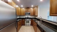 This thoughtfully designed 2-bedroom, 2-bathroom residence offers a practical and well-organized single-floor layout. The kitchen is a standout feature, showcasing warm honey-toned wood cabinetry that extends to the ceiling for ample storage, complemented by sleek dark granite countertops that provide a striking contrast. Stainless steel appliances — including a gas range, built-in microwave, refrigerator, and dishwasher — give the kitchen a modern, polished feel. The neutral tile flooring ties the space together and adds to the clean, cohesive aesthetic. Recessed lighting throughout the kitchen ensures a bright and functional workspace. The U-shaped kitchen layout maximizes efficiency while offering generous counter space for meal preparation. The overall design balances classic warmth with contemporary finishes, creating a welcoming atmosphere throughout the home. With two full bathrooms and two well-proportioned bedrooms, this residence is well-suited for a variety of living arrangements, offering both comfort and practicality in a smartly configured floor plan.