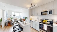 Located at 570 N Fifth St in Philadelphia's vibrant Northern Liberties neighborhood, this well-appointed 2-bedroom, 2-bathroom residence offers a thoughtfully designed open-concept layout with modern finishes throughout. Light hardwood flooring flows seamlessly across the living areas, complementing the bright, airy atmosphere created by large floor-to-ceiling windows that frame sweeping panoramic views of the Philadelphia skyline.

The kitchen is a standout feature, showcasing sleek light gray cabinetry, a white subway tile backsplash, stainless steel appliances including a refrigerator, range, microwave, and dishwasher, and a white quartz waterfall island with bar seating — ideal for casual dining and entertaining. A contemporary pendant light fixture adds a stylish finishing touch.

The living room is generously proportioned, bathed in natural light, and offers impressive elevated city views. The primary bedroom is a comfortable retreat with ample space, while the second bedroom also benefits from large windows with scenic urban vistas. Two dedicated closets, including a walk-in, provide excellent storage. Both bathrooms are finished with large-format tile flooring, white vanities, and full-width mirrors. The overall ambiance is clean, modern, and bright throughout.