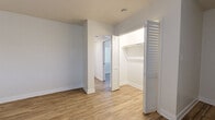 Studio Unit B at 241 S Olive Ave in Alhambra, California is a thoughtfully designed single-floor studio unit that combines modern finishes with functional living. The main living area features warm wood-look vinyl flooring, neutral light gray walls, and a wall-mounted HVAC unit for year-round climate control. A horizontal window along the exterior wall allows natural light to filter into the space, and a built-in closet with classic louvered bifold doors provides convenient storage directly within the living area.

The kitchen is a standout feature, outfitted with crisp white shaker cabinetry, gray countertops, and a white subway tile backsplash. Stainless steel appliances — including a gas range, over-the-range microwave, and refrigerator — lend a contemporary feel, while the clean, galley-style layout maximizes efficiency.

A dedicated sleeping or secondary area off the main hall includes an additional louvered bifold closet with built-in shelving, offering ample storage. The full bathroom is finished with a white vanity with gray countertop, a combination shower and tub, and matching wood-look flooring, maintaining a cohesive aesthetic throughout the unit. Clean lines and a neutral palette give the entire space a fresh, move-in-ready feel.