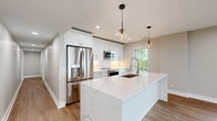 Located at 550 Sheridan Square in Evanston, IL, this well-appointed 3-bedroom, 2-bathroom residence offers a thoughtfully designed single-floor layout with modern finishes throughout. Wide-plank hardwood flooring flows seamlessly across the entire unit, lending warmth and continuity to every room.

The open-concept kitchen and living area serves as the heart of the home. The chef's kitchen is highlighted by a large waterfall-edge quartz island with an undermount sink, crisp white shaker cabinetry extending to the ceiling, stainless steel appliances, a decorative tile backsplash, and stylish globe pendant lights. The expansive living room features recessed lighting, large windows, and sliding glass doors that open directly onto a private balcony with views of lush greenery.

The generously sized primary bedroom offers a walk-in closet outfitted with custom shelving and hanging rods, providing ample storage. Additional bedrooms are well-proportioned, each with natural light from windows framing outdoor tree canopy and lake views. The two bathrooms are finished with clean, contemporary tile work, including a soaking tub with textured white tile surround. A dedicated utility room and closet round out the functional layout, making this a complete and livable residence in a desirable Evanston location.