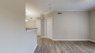 This 550 square foot apartment in Louisville, KY, offers a well-designed living space with contemporary features. The single-bedroom unit boasts an open floor plan, maximizing the use of space. Throughout the apartment, wood-look flooring creates a warm, modern aesthetic. The kitchen is equipped with dark cabinetry, granite countertops, and black appliances, including a built-in microwave. A breakfast bar separates the kitchen from the living area, enhancing the open concept feel. The bedroom, measuring 140 square feet, features a large window and a ceiling fan for comfort. French doors in one room lead to a balcony or patio, allowing natural light to flood the space. The bathroom includes a shower/tub combination with white tiling. Additional amenities include ample closet space and modern light fixtures. The neutral color palette of the walls provides a blank canvas for personalization. This apartment, part of the Oxmoor Apartments complex, combines functionality with style in a compact yet comfortable living space.