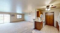 Located at 725 Fredrick Ct in Howard, Wisconsin, this single-floor home offers a practical and well-organized layout across a comfortable footprint. The open-concept kitchen and living room serve as the heart of the home, with the kitchen featuring warm oak cabinetry, light tile flooring, a ceiling fan, and a peninsula that opens to the carpeted living area. White appliances including a refrigerator, range, microwave, and dishwasher are all included. The living room is generously sized, filled with natural light from a large sliding glass door that leads to the outdoors, and includes baseboard heating and a wall-mounted air conditioning unit for year-round comfort. The spacious primary bedroom offers plush carpeting, a sizable closet, and a window with outdoor views. The full bathroom is finished with tile flooring, a wood-tone vanity with a wide countertop and mirror, and a tub/shower combination. Additional conveniences include a dedicated laundry area and an attached single-car garage with an automatic opener. Neutral tones and warm wood accents carry throughout, creating a cohesive and move-in ready atmosphere.