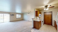 Located at 725 Fredrick Ct in Howard, Wisconsin, this single-floor home offers a practical and well-organized layout across a comfortable footprint. The open-concept kitchen and living room serve as the heart of the home, with the kitchen featuring warm oak cabinetry, light tile flooring, a ceiling fan, and a peninsula that opens to the carpeted living area. White appliances including a refrigerator, range, microwave, and dishwasher are all included. The living room is generously sized, filled with natural light from a large sliding glass door that leads to the outdoors, and includes baseboard heating and a wall-mounted air conditioning unit for year-round comfort. The spacious primary bedroom offers plush carpeting, a sizable closet, and a window with outdoor views. The full bathroom is finished with tile flooring, a wood-tone vanity with a wide countertop and mirror, and a tub/shower combination. Additional conveniences include a dedicated laundry area and an attached single-car garage with an automatic opener. Neutral tones and warm wood accents carry throughout, creating a cohesive and move-in ready atmosphere.