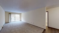Located at 333 Oak Grove St in Minneapolis, Minnesota, this two-bedroom, one-bathroom unit is laid out on a single floor, offering a functional and straightforward floor plan. The living room is generously proportioned, featuring neutral-toned carpet, a textured ceiling, baseboard heating, and a sliding glass door that fills the space with natural light and provides outdoor access. The kitchen is a well-organized galley-style space with white cabinetry, marble-patterned laminate countertops, a double-basin sink, a range, and a refrigerator, all set atop wood-look flooring that extends through the kitchen and dining area. Both bedrooms are carpeted and offer a quiet, comfortable atmosphere, with windows that bring in natural light. The primary bedroom is a spacious retreat, complemented by a closet with louvered bifold doors. The full bathroom features classic white tile surrounding a tub and shower combo, mosaic tile flooring, and a vanity with sink. Baseboard heating is present throughout, ensuring year-round comfort. The overall design is clean and practical, making efficient use of the available space in a well-located Minneapolis neighborhood.