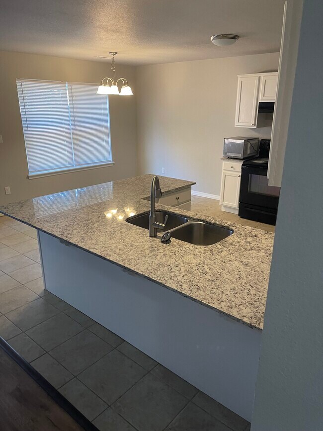 Cocina, encimera de granito y pisos de baldosas. - 2317 W Skyler Dr