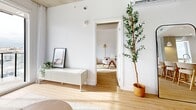 Located at 17 Rue Hyman in Dollard-Des-Ormeaux, this thoughtfully designed 2-bedroom, 2-bathroom unit offers a clean, modern aesthetic throughout its single-floor layout. Light hardwood flooring and crisp white walls create a bright, cohesive atmosphere, while exposed concrete ceilings add an industrial character that contrasts beautifully with the warm finishes.

The open-concept kitchen is a standout feature, equipped with light wood cabinetry, stainless steel appliances, and a generous white quartz island with an undermount sink and seating — ideal for casual dining or entertaining. Natural light filters in through a well-placed window, enhancing the airy feel of the space.

The living room is bathed in natural light from multiple windows with outdoor views, and features the same exposed concrete ceiling detail that runs throughout the unit, lending an urban loft sensibility to the overall design.

The primary bedroom is a comfortable retreat with a natural light source and hardwood flooring, while the second bedroom offers a similarly clean and versatile layout. Both bathrooms are finished with light tile flooring and wood vanities — one featuring a sleek sliding glass shower enclosure, the other a combined tub and shower with a glass panel. The entry hallway sets the tone with its minimalist design and warm, welcoming feel.