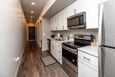 Located on Bluegrass Circle in Cedar Falls, Iowa, this one-bedroom, one-bathroom unit offers a thoughtfully arranged single-floor layout that maximizes every square foot of its compact footprint. The interior is finished with warm hardwood-style flooring throughout, crisp white walls, and a clean, modern aesthetic that lends the space a bright and airy feel.

The living room serves as the heart of the unit, featuring track lighting on the ceiling and a large window that fills the room with natural light while offering views of the surrounding neighborhood. The open layout comfortably accommodates a seating area and a dining space side by side.

The hallway is lined with full-height white panel doors, providing generous built-in storage solutions and contributing to the unit's clean, uncluttered look. The doors' floor-to-ceiling design creates a sense of visual continuity along the corridor.

The bedroom is a well-proportioned private retreat with white walls, hardwood-style flooring, a closet, and sufficient space for a full-sized bed and additional furnishings. Subtle ceiling ventilation ensures year-round comfort.

The bathroom maintains the same clean, neutral palette, featuring a white vanity, a combination tub and shower, and hardwood-style flooring, completing the unit's consistent and functional design throughout.
