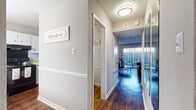 This two-floor residence offers a thoughtfully arranged layout across multiple rooms, blending functional design with warm interior finishes. Dark hardwood-style flooring flows throughout the main living areas, creating a cohesive and polished look, while plush carpeting adds comfort to each of the three bedrooms.

The living room is a welcoming space filled with natural light streaming through large vertical-blind-covered sliding doors, hinting at outdoor access. A hallway connects the living area to the rest of the home, featuring a mirrored wall that enhances the sense of space.

The kitchen is efficiently designed with ample white cabinetry, light granite-style countertops, and black appliances, including a range, dishwasher, and microwave. A window above the sink brings in natural light, adding brightness to the workspace.

The dining area features rich dark hardwood flooring, a modern chandelier, and a window that allows natural light to complement the intimate setting.

Each bedroom is well-proportioned, featuring ceiling fans with lighting, windows with blinds for natural light control, and closet access. The textured ceilings are consistent throughout the home, adding a classic residential character to every room.
