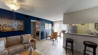 Located at 2020 Armstrong Mill Rd in Lexington, Kentucky, this thoughtfully designed single-floor residence combines contemporary finishes with bold, colorful accents to create a warm and inviting atmosphere throughout. The open-concept layout connects the living, dining, and kitchen areas seamlessly, making the space feel expansive and cohesive.

The living room is anchored by a striking navy blue accent wall, light hardwood-style flooring, and generous natural light streaming through large windows with blinds and drapes. A fireplace adds a cozy focal point, while a breakfast bar with bar stools bridges the transition to the kitchen. The kitchen is well-equipped with dark espresso cabinetry, granite countertops, stainless steel appliances including a refrigerator, range, and microwave, and a double basin sink. The dining area sits adjacent to a sliding glass door that opens to an outdoor view, allowing abundant light to pour in.

The bedroom features plush carpeting, a warm burnt-orange accent wall, and ample natural light from a window with patterned curtains. The bathroom includes granite vanity countertops, dark cabinetry, and a shower-tub combination. A textured ceiling is consistent throughout the residence, adding architectural character to each room.