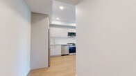 Located at 1112 McCallum Rd in Langford, BC, this thoughtfully designed 2-bedroom, 2-bathroom unit offers a clean, modern aesthetic throughout. The open-concept living and kitchen area is anchored by warm light wood-look flooring and crisp white walls, creating a bright and welcoming atmosphere. The kitchen is well-appointed with stainless steel appliances including a full-size refrigerator and range, white upper cabinetry, warm wood lower cabinets, and a tray ceiling with recessed lighting. A stacked in-unit washer and dryer adds everyday convenience. The living area flows naturally toward a large glazed door that opens to outdoor views of a serene waterway and lush tree canopy. Both bedrooms are generously sized relative to the overall footprint, bathed in natural light from large windows framing picturesque views of greenery. The primary bedroom features a built-in sliding door closet for efficient storage. Both bathrooms are finished with the same consistent palette — wood-toned vanities, white quartz countertops, and full soaking tub/shower combinations. Baseboard heating is present throughout. The overall design emphasizes light, simplicity, and connection to the natural surroundings of Langford.