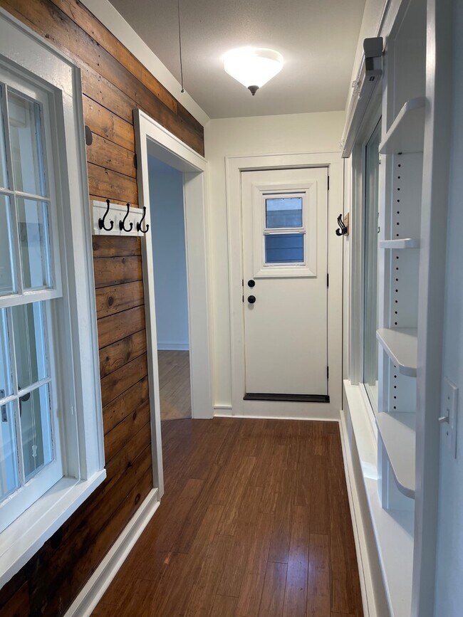 Entry hallway w/ original architectural elements, bamboo flooring & private front porch access. - 2650 S Shore Dr