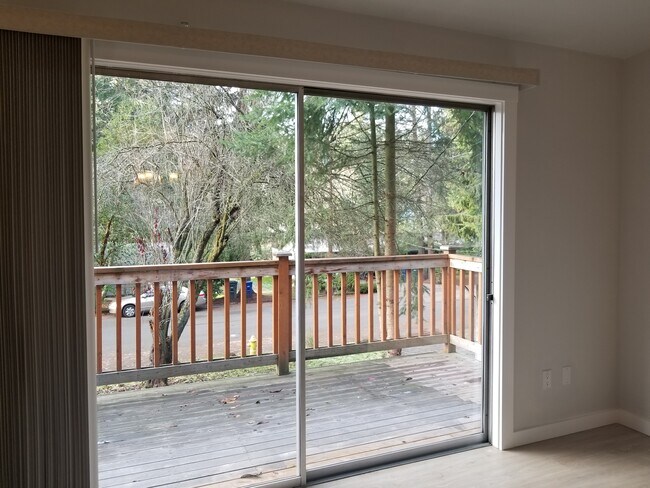 El salón tiene acceso a una amplia terraza con vistas a un bonito y tranquilo jardín delantero. - 4070 149th Ave SE