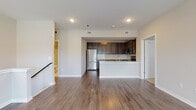 This single-floor residence in Bartlesville, Oklahoma, presents a well-designed layout that balances open communal spaces with functional private rooms. The living area is expansive and filled with natural light from a large window, featuring rich, dark hardwood-style flooring that extends throughout the main living and kitchen spaces, lending warmth and continuity to the design.

The kitchen is positioned at the heart of the home in a semi-open configuration, defined by dark espresso cabinetry, a classic tile backsplash, light granite countertops, and a full suite of stainless steel appliances. A peninsula counter provides additional workspace and creates a natural boundary between the kitchen and living area.

The bedrooms feature soft, neutral-toned carpeting and are generously proportioned, with windows allowing natural light to brighten each room. Closet access is included in the bedroom areas, adding practical storage.

Two bathrooms serve the unit, each finished with matching dark cabinetry, granite-topped vanities, and light tile flooring. One bathroom includes a tub-shower combination, while the other features a walk-in shower stall. Neutral wall tones and recessed lighting throughout the unit create a clean, cohesive ambiance well-suited to a variety of interior styles.