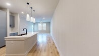 Located at 750 W Grand Pkwy S in Katy, TX, this thoughtfully designed one-bedroom, one-bathroom unit offers a well-appointed single-floor layout with modern finishes throughout. The open-concept living and kitchen area is anchored by light hardwood-style flooring that flows seamlessly through the main spaces. The kitchen is a standout feature, equipped with gray shaker-style cabinetry, white quartz countertops, a large center island with an undermount sink and matte black faucet, stainless steel appliances including a refrigerator, range, microwave, and dishwasher, and a white subway tile backsplash. Elegant pendant lighting hangs above the island, adding a modern touch. The living room receives ample natural light through multiple windows with blinds and includes a ceiling fan for added comfort, along with direct access to an exterior door. The bedroom offers plush carpeting, a ceiling fan, a window with neighborhood views, and a dedicated closet. The bathroom is well-finished with gray cabinetry, a white quartz vanity, a large mirror, matte black fixtures, and a glass-enclosed shower with marble-style tile surround. Clean neutral tones and recessed lighting contribute to a bright, contemporary ambiance throughout the unit.