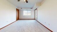 This single-floor unit at 42nd Ave W in Alexandria, Minnesota, offers a well-organized layout designed for practical, everyday living. The kitchen serves as a functional centerpiece, finished with light hardwood-style flooring and outfitted with stainless steel appliances, including a refrigerator, electric range, and built-in microwave. Rich medium-toned wood cabinetry lines both sides of the galley-style kitchen, complemented by light granite-look countertops and a stainless steel sink. A pass-through counter connects the kitchen to the living area, enhancing the open feel of the space.

The living area is generously sized, featuring plush neutral carpeting, a ceiling fan, and a window that allows natural light to filter in alongside views of the surrounding neighborhood. Bold red-toned baseboards provide a consistent design detail throughout the carpeted rooms, adding warmth to the otherwise neutral palette.

The bedrooms are spacious and bright, with soft carpet underfoot. At least one bedroom includes a closet with a hanging rod, offering practical storage. The bathroom features a full soaking tub with chrome fixtures set against clean, white surround walls. Overall, the unit presents a clean, move-in-ready environment with a cohesive and functional interior design.