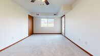 This single-floor unit at 42nd Ave W in Alexandria, Minnesota, offers a well-organized layout designed for practical, everyday living. The kitchen serves as a functional centerpiece, finished with light hardwood-style flooring and outfitted with stainless steel appliances, including a refrigerator, electric range, and built-in microwave. Rich medium-toned wood cabinetry lines both sides of the galley-style kitchen, complemented by light granite-look countertops and a stainless steel sink. A pass-through counter connects the kitchen to the living area, enhancing the open feel of the space.

The living area is generously sized, featuring plush neutral carpeting, a ceiling fan, and a window that allows natural light to filter in alongside views of the surrounding neighborhood. Bold red-toned baseboards provide a consistent design detail throughout the carpeted rooms, adding warmth to the otherwise neutral palette.

The bedrooms are spacious and bright, with soft carpet underfoot. At least one bedroom includes a closet with a hanging rod, offering practical storage. The bathroom features a full soaking tub with chrome fixtures set against clean, white surround walls. Overall, the unit presents a clean, move-in-ready environment with a cohesive and functional interior design.