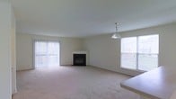 Located at 100 N Barrett Lane in Newark, Delaware, this three-floor home offers a well-structured layout designed for comfortable living. The main living area is a standout feature, showcasing a classic fireplace as a central focal point, framed by neutral, light-toned walls and plush carpeting that creates a warm and inviting atmosphere. Large sliding glass doors open to an outdoor area, flooding the room with natural light, while an additional window on the adjacent wall further brightens the space. A pendant light fixture adds a subtle decorative touch overhead. The open, airy feel of the living area allows for flexible furniture arrangements to suit a variety of lifestyles. Spanning three floors, the home provides ample room for living, sleeping, and additional functional spaces across its levels. The clean, neutral palette throughout offers a versatile canvas for personalization. With its combination of natural light, a cozy fireplace, and a multi-floor layout, this Newark property delivers a balanced blend of comfort and practicality in a residential setting.