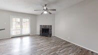 Located at 2022 Remington Dr in Arlington, TX, this single-story, 3-bedroom, 1-bathroom home offers a practical and efficiently designed layout. Wood-look plank flooring flows consistently throughout every room, creating a cohesive and easy-to-maintain interior. The living room serves as the heart of the home, featuring a tile-surround fireplace, a ceiling fan with light kit, and a glass door that brings in natural light. The kitchen and living area share an open connection, with the kitchen showcasing white cabinetry, a granite-style countertop peninsula, stainless steel appliances including a gas range and refrigerator, and overhead ventilation. Each of the three bedrooms is equipped with a ceiling fan and benefits from natural light via blinded windows. The bedrooms include generous closet space, with walk-in closets featuring built-in shelving and hanging rods. The bathroom is clean and straightforward, with a full tub-shower combination finished in white tile. Textured ceilings are present throughout the home, complementing the neutral gray wall tones. A hallway connects the bedrooms, providing a well-organized flow through the residence.