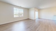 Located at 1115 York Rd in Gettysburg, PA, this well-appointed 2-bedroom, 1-bathroom unit offers a clean, modern aesthetic across a single floor. The open-concept kitchen and living area serves as the heart of the home, featuring white shaker-style cabinetry, dark countertops, stainless steel appliances including a refrigerator, range, and microwave, and a peninsula island with seating and elegant pendant lighting overhead. Recessed lighting and large windows allow natural light to fill the space, which is unified throughout by warm, light hardwood-style flooring and crisp white walls and trim. The spacious living room benefits from multiple windows with outdoor views, creating a bright and airy atmosphere. The primary bedroom is generously sized and includes a double-door closet for ample storage. The second bedroom also features a window with natural light, providing a comfortable and functional space. The full bathroom is finished with white shaker vanity cabinetry, dark countertops, a large mirror, brushed nickel fixtures, and a tiled shower-tub combination. Clean lines, neutral tones, and consistent finishes throughout give this unit a cohesive, move-in-ready feel well-suited for modern living in historic Gettysburg.