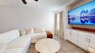 Located in Bedford, TX, this well-appointed 2-bedroom, 2-bathroom single-floor residence offers a thoughtfully designed open-concept layout that seamlessly connects the living, dining, and kitchen areas. Light wood-look flooring flows throughout the main living spaces, complemented by crisp white walls and an abundance of natural light, creating a bright and airy atmosphere. The living room features a ceiling fan and built-in shelving, providing both comfort and functional display space. The kitchen is a standout, outfitted with white shaker cabinetry, granite countertops, stainless steel appliances, and a peninsula with bar seating — ideal for casual dining. A dedicated pantry adds to the kitchen's practicality. The primary bedroom is generously sized, complete with a ceiling fan and ample closet space. The second bedroom is bright and comfortable, featuring a ceiling fan and a large window with outdoor views. Both bathrooms are finished with floor-to-ceiling marble-look tile — one with a walk-in shower with brushed gold fixtures, and the other with a tub-shower combination. A private balcony extends the living space outdoors. With six closets throughout, storage is plentiful. The unit also includes a hallway connecting the key areas for a cohesive and functional flow.