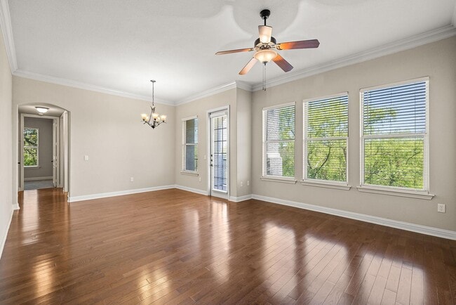 Spacious living and dining room with wood styled flooring and natural light - Marquis at TPC