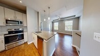 This 990 sq ft, 2-bedroom, 2-bathroom apartment at 9015 Eager Rd, Unit 4304, St. Louis, MO offers a thoughtfully designed single-floor layout. The open-concept kitchen and living area features hardwood-style flooring, a granite-topped island with pendant lighting, stainless steel appliances, and large windows that invite natural light. The living room includes a ceiling fan and ample space. Both bedrooms are carpeted with natural light from windows; the second bedroom showcases a distinctive angled roofline. Two full bathrooms include tub-shower combos, and the unit also offers two closets with wire shelving for generous storage.