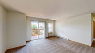 Located at 1420 Commons Dr in Woodstock, IL, this well-appointed two-bedroom, two-bathroom unit offers a practical and comfortable single-floor layout. The living room is generously sized, featuring plush carpeting, neutral walls, and a sliding glass door that opens onto a private balcony with outdoor views — bringing in natural light and a sense of openness. A wall-mounted HVAC unit ensures year-round comfort, while an additional window further brightens the space.

The galley-style kitchen is efficiently designed with warm honey-toned wood cabinetry, granite-look countertops, a full suite of white appliances including a range, refrigerator, and dishwasher, and easy-care hardwood-style flooring. A peninsula counter separates the kitchen from the adjoining living area, making it ideal for casual dining or entertaining.

The primary bedroom is a standout, featuring vaulted ceilings that lend an airy, elevated feel, along with soft carpeting and a wall-unit for climate control. The second bedroom is equally comfortable, with plush carpet and a bright window overlooking the exterior grounds. Both bathrooms are fitted with full soaking tub and shower combinations. A dedicated closet with wire shelving provides additional storage throughout the unit.