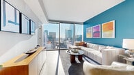 Located at 401 S. Graham Street in the heart of uptown Charlotte, this two-bedroom, two-bathroom residence offers a well-appointed single-floor layout designed with contemporary urban living in mind. The open-concept living and kitchen area serves as the centerpiece of the home, anchored by dramatic floor-to-ceiling windows that flood the space with natural light and frame commanding views of the Charlotte skyline. A bold teal accent wall adds a vibrant focal point to the living area, complementing the light wood flooring that runs throughout.

The kitchen features white flat-front cabinetry, subway tile backsplash, stainless steel appliances, and a peninsula with seating—ideal for both everyday dining and entertaining. The primary bedroom is generously sized, featuring a teal accent wall, a ceiling fan, light wood flooring, direct access to a dedicated closet, and an en-suite bathroom. The second bedroom is well-proportioned and similarly finished. Both bathrooms offer clean, modern design with white vanities, tile flooring, and subway-tiled tub-shower combinations. The overall ambiance is modern, bright, and distinctly urban.