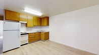 Located at 9703 Winter Gardens Boulevard in Lakeside, CA, this single-story one-bedroom unit offers a practical and well-organized layout. Light wood-style flooring runs consistently throughout the space, creating a clean and cohesive look from room to room.

The kitchen is equipped with warm oak-toned cabinetry spanning both upper and lower storage, a white electric range, refrigerator, and a double basin sink set into an L-shaped counter configuration. Bright fluorescent lighting overhead and a window with vertical blinds allow natural light to fill the kitchen area. A wall-mounted HVAC unit provides climate control.

The bedroom is a comfortable size, featuring a ceiling fan with integrated lighting and neutral-toned walls that contribute to a calm atmosphere. A dedicated walk-in closet off the bedroom offers a wraparound hanging rod and open shelving, providing ample storage capacity. The floor plan's efficient design connects all areas with ease, making the most of the available space.

Overall, the unit presents a clean, functional living environment with consistent finishes and practical amenities suited for everyday living.