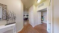 Located at 1600 S Taft Ave in Loveland, Colorado, this single-level 2-bedroom, 2-bathroom residence offers a comfortable and well-designed living environment. Warm hardwood-style flooring flows through the entryway, hallway, kitchen, and bathrooms, creating a cohesive aesthetic throughout. The inviting living room is a standout feature, centered around a sleek built-in fireplace and a sliding glass door that fills the space with natural light and provides views of the outdoors. The kitchen is outfitted with dark cabinetry, granite-style countertops, stainless steel appliances including a range, microwave, and refrigerator, and track lighting overhead. A dedicated dining area adjoins the kitchen, ideal for everyday meals. The primary bedroom is generously sized, with a ceiling fan, plush carpet, and a window offering pleasant outdoor views. The second bedroom is equally comfortable, also featuring carpet and a natural light-filled window. Both bathrooms are finished with dark vanity cabinetry and hardwood-style flooring. Additional conveniences include in-unit laundry, multiple closets for ample storage, and a hallway that efficiently connects all areas of the home. The overall ambiance is warm, modern, and move-in ready.
