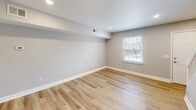 Located at 500 Savannah St in Greensboro, NC, this two-story, 2-bedroom, 2-bathroom home offers a well-organized layout spread across two floors. The main level features a bright living area with light hardwood-style flooring, recessed lighting, and neutral gray walls that create a clean, modern aesthetic. A sliding glass door fills the space with natural light and opens to a view of lush, wooded surroundings. The kitchen is well-appointed with white shaker-style cabinetry, light countertops, stainless steel appliances including a refrigerator, dishwasher, and range, and matching hardwood-style flooring that ties the main living areas together cohesively. Both bedrooms are finished with plush carpeting and large windows fitted with blinds that invite natural light while maintaining privacy. The primary bedroom stands out with dual louvered bi-fold closets, offering generous storage. The second bedroom also features ample closet space. The bathrooms include a full tub-and-shower combo with white tile surround and brushed nickel fixtures. A connecting hallway links the rooms efficiently across both levels, completing a practical and comfortable floor plan.