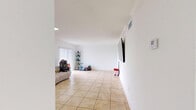 Located in Hialeah, FL, this single-floor unit offers a well-organized layout across one bedroom and three bathrooms. The open-plan living area is bright and airy, featuring large light-toned ceramic tile flooring that runs throughout the entire space, clean white walls, and recessed lighting that enhances the sense of openness. A sliding glass door with vertical blinds in the living room allows natural light to flow in freely.

The kitchen is efficiently designed with white cabinetry, marble-look countertops, stainless steel appliances including a full-size refrigerator and range, and a peninsula with bar seating — making it both functional and inviting. The layout allows the kitchen to open naturally toward the living area, promoting an easy flow between spaces.

The spacious primary bedroom is a comfortable retreat with clean white walls, tile flooring, and ample room for furnishings. A dedicated closet adds practical storage. The hallway connects the rooms smoothly and leads to the bathrooms, which are finished with tile flooring, vanities with stone-look countertops, and a tub-shower combination in one. The crisp, neutral palette throughout gives the entire unit a clean, cohesive feel.