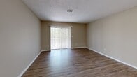 Located at 4658 Mercer University Drive in Macon, Georgia, this one-bedroom, two-bathroom unit offers a well-organized single-floor layout designed for comfortable everyday living. The interior features warm wood-look vinyl plank flooring throughout the main living areas, complemented by neutral beige walls and textured ceilings that create a cohesive, understated aesthetic.

The kitchen is efficiently designed with white cabinetry, light countertops, a double-basin sink, and black appliances including a refrigerator and dishwasher. It opens conveniently toward the dining area, allowing for an easy flow between spaces. The combined kitchen and living room area is anchored by a large sliding glass door dressed with vertical blinds, allowing natural light to fill the room.

The spacious bedroom is finished with plush carpeting and includes access to a closet, providing ample storage. The two bathrooms are well-appointed, featuring dark wood vanities, bright vanity lighting, large mirrors, and tub-shower combinations with light wood-look flooring.

A dedicated laundry room includes washer hookups and a built-in shelf, adding practical convenience. Two closets throughout the unit offer additional storage capacity. The layout flows intuitively from a central hallway, making efficient use of the generous overall square footage.