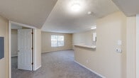 Located at 1004 Lindsey Loop in London, Ohio, this single-floor, 2-bedroom, 2-bathroom home offers a practical and comfortable layout designed for everyday living. The open living area features soft, neutral-toned walls, plush wall-to-wall carpeting, and a textured ceiling, creating a warm and inviting atmosphere. A pass-through breakfast bar connects the living space to the kitchen, enhancing the sense of openness. Natural light filters in through windows that provide pleasant outdoor views.

The galley-style kitchen is efficiently designed with white cabinetry, ample counter space, a full suite of appliances including a range and refrigerator, and durable tile flooring. A utility sink adds further functionality.

Both bedrooms are carpeted and finished in the same warm neutral palette, each offering natural light through windows with blinds. The spacious primary bedroom includes a walk-in closet outfitted with wire shelving for organized storage. A second closet serves the additional bedroom.

Both bathrooms are identically appointed with white vanities, large mirrors with overhead lighting, tile flooring, and a tub-shower combination. A dedicated utility room rounds out the layout, adding practical storage and laundry space. The home's consistent, clean finishes make it move-in ready.