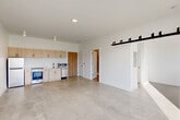 Located at 3740 Second St in Detroit's vibrant Midtown neighborhood, this 1-bedroom, 1-bathroom unit offers a clean, modern aesthetic defined by an open-concept layout and thoughtful industrial-inspired design. Polished concrete floors run throughout, lending the space a contemporary loft-like character that ties every room together seamlessly.

The combined living, dining, and kitchen area forms the heart of the unit. The kitchen features light wood cabinetry, stainless steel appliances including a gas range and dishwasher, and a built-in microwave — all arranged efficiently along one wall. A striking black sliding barn door serves as a bold architectural accent, separating spaces while adding an industrial edge to the otherwise clean, white interior.

The living area is bathed in natural light through large windows that frame views of the surrounding Detroit streetscape and neighboring brick architecture, creating a bright and airy atmosphere. The bedroom, accessed through its own door, is a cozy and well-lit retreat with a tall window that brings in additional natural light.

The bathroom features polished concrete floors, white subway tile in the walk-in shower, and a handheld showerhead fixture with brushed gold hardware. Additional conveniences include two closets and an in-unit laundry area, completing this efficiently designed and stylish urban residence.