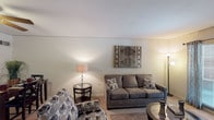 This two-story townhome offers two bedrooms and two and a half bathrooms across a well-organized and comfortable floor plan. The main living area features carpeted flooring, neutral-toned walls, and a sliding glass door that fills the space with natural light while providing views of the outdoors. The living room accommodates generous seating and flows seamlessly into the dining area, creating an inviting space for both relaxing and entertaining.

The galley-style kitchen is equipped with dark wood cabinetry, white appliances including a range, refrigerator, and dishwasher, along with ample counter space and tile flooring. A dedicated pantry with louvered bifold doors provides additional storage.

The half bathroom on the main level features white subway tile wainscoting, a single vanity with a large mirror, and bright overhead lighting. Upstairs, the primary bedroom offers carpeted flooring and a ceiling-mounted light fixture, while the second bedroom features a ceiling fan, a natural-light window, a louvered closet, and space for multiple beds. Each full bathroom upstairs includes a single vanity, tiled walls, and a shower-tub combination. Overall, the townhome presents a clean, neutral palette with practical amenities throughout both floors.