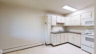 Located at 509 18th St in Greeley, Colorado, this two-bedroom, one-bathroom single-floor unit offers a practical and straightforward layout. The kitchen is well-equipped with white cabinetry providing ample upper and lower storage, dark laminate countertops, a double sink, a tile backsplash, and white appliances including an electric range, microwave, and refrigerator. Light tile flooring and a skylight-style ceiling fixture keep the space bright and functional. The living and dining areas flow together, offering a comfortable shared space for everyday use. Both bedrooms feature neutral carpet flooring, white panel walls, and natural light from windows with blinds. Each room includes closet storage — with a total of four closets throughout the unit — offering generous organizational capacity relative to the overall footprint. The full bathroom is finished with classic white subway tile walls, mosaic tile flooring, a tub-shower combination, and a baseboard heater. Throughout the unit, textured ceilings and baseboard heating are consistent features. The compact yet efficient layout makes thoughtful use of every area, connecting rooms through a central hallway for easy navigation.