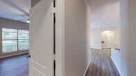 This single-floor residence offers a thoughtfully designed layout with a clean, modern aesthetic throughout. Durable hardwood-style flooring runs continuously across all living areas, bedrooms, and hallways, creating a cohesive and easy-to-maintain interior. The open living and dining area is accented with crown molding, a ceiling fan with light fixture, and natural light streaming in through multiple windows and a glass-paneled door that leads to the exterior. An elegant arched entryway connects the living space to the rest of the unit, adding an architectural touch to the layout. The galley-style kitchen is well-equipped with white shaker cabinetry, dark countertops, a subway tile backsplash, and a full suite of stainless steel appliances including a refrigerator, range, microwave, and dishwasher. Two generously sized bedrooms each feature ceiling fans, large windows with outdoor views, and ample closet space — one bedroom includes a spacious built-in closet with shelving and hanging rods. Both bathrooms are finished with white tub-shower combinations, neutral tile surrounds, and brushed nickel fixtures, with one bathroom featuring a white vanity with a framed mirror and dark countertop. The overall ambiance is neutral, clean, and move-in ready.