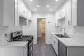 Located at 2230 W Orange Ave in Anaheim, CA, this well-appointed 1-bedroom, 1-bathroom unit offers a thoughtfully designed single-level layout. The open living room greets you with wood-style laminate flooring, crown molding, a textured ceiling, and a large picture window that fills the space with natural light. The layout flows seamlessly into a dedicated dining area, complete with a ceiling fan and a view of the outdoors. The galley-style kitchen is bright and modern, featuring crisp white shaker cabinetry, white quartz countertops, a stainless steel sink, recessed lighting, and stainless steel appliances including a gas range and dishwasher. The spacious bedroom is carpeted for comfort, adorned with crown molding, and benefits from generous natural light through sliding glass doors that open directly to a private patio. Mirrored sliding closet doors enhance the sense of space. The bathroom is well-equipped with a tub/shower combo featuring tile surround and sliding glass doors, a white vanity, and wood-style flooring. A hallway connects the living areas to the bedroom and bathroom, with two closets providing ample storage throughout the unit.