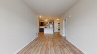 Located at 2200 Seasons Blvd in West Dundee, Illinois, this single-floor residence offers a thoughtfully designed open-concept layout that seamlessly connects the living, dining, and kitchen areas. Light wood-look flooring flows throughout the main living spaces, creating a warm and cohesive aesthetic.

The kitchen is a standout feature, showcasing rich dark wood cabinetry, a large center island with a double-basin sink and white countertops, and a full suite of stainless steel appliances including a refrigerator, microwave, and range. Pendant lighting above the island adds a modern touch, while recessed and flush-mount ceiling fixtures provide ample illumination throughout.

Conveniently tucked adjacent to the kitchen is an in-unit stacked washer and dryer, adding everyday practicality to the space. The bedrooms are carpeted for comfort, with neutral tones and natural light from windows with blinds. The primary bedroom features a spacious walk-in closet with built-in shelving and rod systems. The bathroom is clean and functional, outfitted with a full soaking tub and shower combination with tiled surround and chrome fixtures. The overall ambiance is modern, clean, and move-in ready.