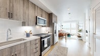 Located at 37 8th Ave in Oakland, CA, this thoughtfully designed one-bedroom, one-bathroom residence offers a modern and efficient layout across a single floor. Light wood flooring flows throughout, creating a cohesive and airy feel.

The kitchen is a standout feature, outfitted with floor-to-ceiling wood-grain cabinetry, a white subway tile backsplash, quartz countertops, and a full suite of stainless steel appliances including a gas range, over-the-range microwave, French door refrigerator, and dishwasher. The kitchen opens directly into the combined living and dining area, making the space feel open and connected.

The living room benefits from large windows that frame expansive outdoor views, flooding the space with natural light. An open shelving unit adds both storage and a stylish design element.

The bedroom continues the view-forward design with oversized windows offering scenic vistas. A dedicated closet provides organized storage. The bathroom is clean and well-appointed, featuring a soaking tub with tiled surround, a built-in niche, wood-toned vanity cabinetry, and white quartz countertops.

A hallway with a louvered closet connects the entry to the main living areas, completing this well-organized and contemporary Oakland residence.