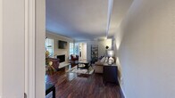 This thoughtfully designed single-floor residence offers a seamless blend of comfort and modern finishes across its efficiently organized layout. The open-concept living, dining, and kitchen area forms the heart of the home, anchored by rich dark hardwood flooring that extends throughout the main living spaces. The living room features crown molding, a tray ceiling detail, and a wood-burning fireplace framed by a classic tile surround, creating a warm and inviting atmosphere. Natural light filters in through plantation-shuttered windows, enhancing the neutral color palette throughout.

The kitchen is equipped with stainless steel appliances, white cabinetry with a mosaic tile backsplash, and a granite-topped breakfast bar that doubles as a casual dining space. A dedicated dining area sits adjacent, offering an intimate setting for meals.

The bedroom is carpeted for comfort and includes a ceiling fan, generous natural light from a large window with blinds, and direct access to a spacious walk-in closet outfitted with dual hanging rods and shelving. The bathroom features granite countertops, white cabinetry, and a fully tiled soaking tub and shower combination with a decorative mosaic border accent. Dark hardwood flooring continues into the bathroom, maintaining a cohesive design aesthetic throughout the unit.