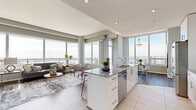 Located in the heart of San Diego at 1475 Island Ave, this high-rise residence offers a sophisticated urban living experience defined by sweeping panoramic views and contemporary design throughout. Floor-to-ceiling windows flood the open-concept living and dining areas with abundant natural light, framing stunning views of the San Diego skyline and beyond. The seamlessly connected layout creates an airy, expansive feel as the living space flows into the dining area and kitchen.

The kitchen is thoughtfully designed with sleek white cabinetry, granite countertops, a large center island with a built-in sink and dishwasher, and premium stainless steel appliances including a wall oven and microwave. Large-format tile flooring grounds the space, while hardwood floors extend throughout the rest of the residence.

The bedroom is generously sized, bathed in natural light from oversized windows, and complemented by a well-appointed walk-in closet featuring custom shelving and dual hanging rods. The bathroom offers a clean, modern aesthetic with granite countertops, white cabinetry, and polished chrome fixtures.

A private balcony with glass railings and bold yellow accent panels delivers breathtaking elevated views of the city and surrounding landscape, making it an exceptional outdoor retreat. The entryway is welcoming and well-proportioned, completing this polished urban residence.