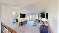 This thoughtfully designed two-bedroom, two-bathroom residence in Midland, Michigan offers comfortable single-floor living with a functional and welcoming layout. The spacious living room features plush carpeting, vaulted-style ceilings, and an arched window that fills the space with natural light. French doors lead directly to a private outdoor deck, seamlessly connecting interior and exterior living. The dining area, positioned adjacent to the living room, also benefits from deck access through its own set of French doors, creating an airy, open atmosphere ideal for entertaining. The kitchen is equipped with white cabinetry featuring wood-trim detailing, a range, dishwasher, and a window above the sink that brings in additional natural light. The primary bedroom is generously sized, featuring large windows with outdoor views and soft carpeted flooring. The primary bathroom includes a dual-sink vanity with a marble-patterned countertop, a well-lit mirror, and a separate tub and shower area. A dedicated in-unit laundry space with a full-size washer and dryer adds everyday convenience. Throughout the residence, neutral tones and soft carpeting contribute to a calm, cohesive aesthetic. A hallway connects all rooms efficiently, rounding out this well-appointed home.