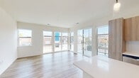 Located at 4733 S Packard Ave in Cudahy, Wisconsin, this well-appointed 2-bedroom, 2-bathroom unit offers a thoughtfully designed single-floor layout. The open-concept living and kitchen area is anchored by light wood-tone flooring throughout, creating a warm and cohesive feel. Large windows and a glass door flood the living room with natural light while providing direct access to a private balcony overlooking the surrounding streetscape.

The kitchen is a standout feature, equipped with stainless steel appliances including a refrigerator, range, and microwave, complemented by light wood cabinetry, a white subway tile backsplash, and a spacious center island with a clean white countertop. Pendant lighting above the island adds a modern finishing touch.

The primary bedroom is generously sized with dedicated closet space, while the second bedroom offers plush carpeting and a window with outdoor views. Both bedrooms provide a quiet, comfortable retreat. The primary bathroom features a glass-enclosed shower, wood-finish vanity with white countertop, and hardwood-style flooring. The second bathroom includes a full tub-shower combo with built-in shelving. A dedicated laundry room with hookups and shelving adds everyday convenience, completing this functional and modern home.