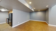 Located at 4102 W Osborn Rd in Phoenix, Arizona, this single-floor unit offers a well-organized layout comprising a main living area, a kitchen, and a full bathroom. The open main living space is finished with warm-toned tile flooring and cool gray walls, creating a clean and neutral aesthetic. Recessed lighting is embedded throughout, with a textured ceiling adding subtle dimension. A large window with vertical blinds allows natural light to filter in, brightening the interior. A stepped ceiling detail in the living area adds architectural interest while partially enclosing a cozier zone within the open floor plan. The kitchen is efficiently designed with warm wood cabinetry, granite-style countertops, a double stainless steel sink, and a black electric range with overhead ventilation. Tile flooring continues seamlessly into this space, maintaining visual consistency. The bathroom is straightforward and functional, featuring a single-sink vanity with matching wood cabinetry and granite-style countertops, a toilet, and a full shower-tub combination. Gray walls and tile flooring carry through here as well, tying the overall palette of the unit together. The space presents a clean, move-in-ready condition throughout.