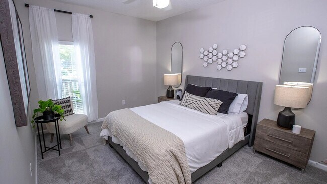 Relájese con estilo y comodidad en nuestros acogedores dormitorios, donde las suaves alfombras y el ventilador de techo crean el ambiente perfecto para relajarse. - 12th and James Luxury Apartments
