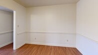 Located in Roanoke, VA, this single-floor residence offers a well-organized layout comprising four bedrooms, two bathrooms, a kitchen, dining room, and hallway. The neutral-toned interiors are accented by warm beige walls and clean white trim throughout.

The generously sized primary bedroom features plush carpeting, natural light from a sliding glass door that opens to a private balcony overlooking mature trees. The three additional bedrooms are carpeted and each include windows that bring in natural light; one features a double louvered-door closet for ample storage.

The dining room is distinguished by warm hardwood-style flooring and elegant chair-rail molding, lending a classic, refined character to the space. The kitchen is equipped with rich wood cabinetry, white countertops, tile flooring, and includes a full suite of appliances — electric range, dishwasher, and refrigerator. A convenient in-unit washer and dryer is tucked just off the kitchen.

The two bathrooms offer distinct configurations: one includes a tiled tub-shower combo, while the other features a glass-enclosed walk-in shower with accessibility grab bars and white tile surround. Together, these spaces deliver a functional and comfortable living environment in a well-established Roanoke community.